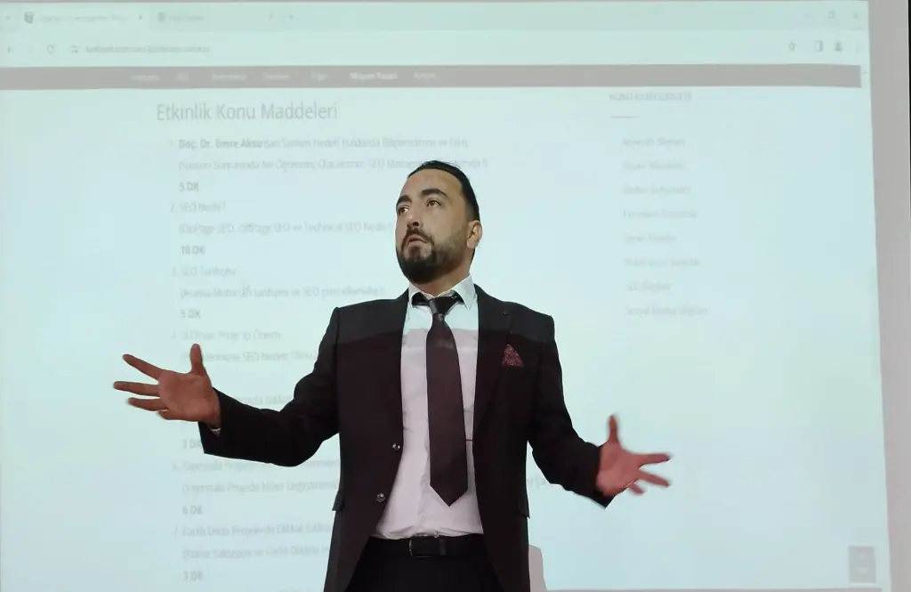 Tahir Dinç bir etkinlikte SEO anlatırken; arkadaki slaytta SEO tarihçesi ve farklı dillerdeki projeler başlıkları görülüyor